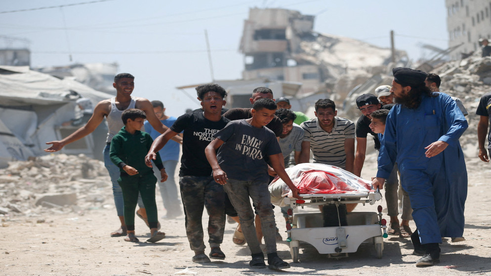 فلسطينيون يجرون جثمان شهيد في مدينة غزة، 19 حزيران 2025. (رويترز)