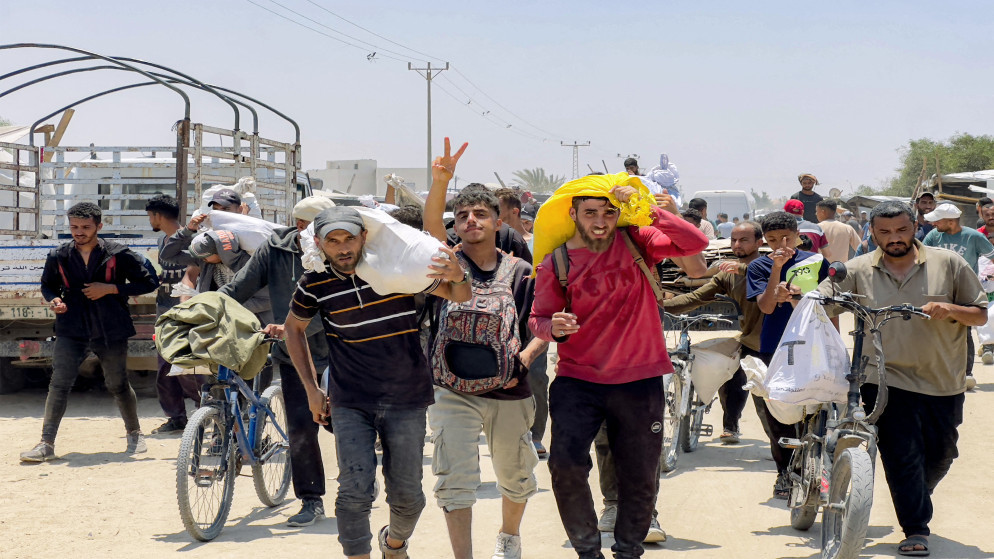 فلسطينيون يتلقون مساعدات إنسانية في رفح جنوبي قطاع غزة في 10 حزيران 2025. (أ ف ب)