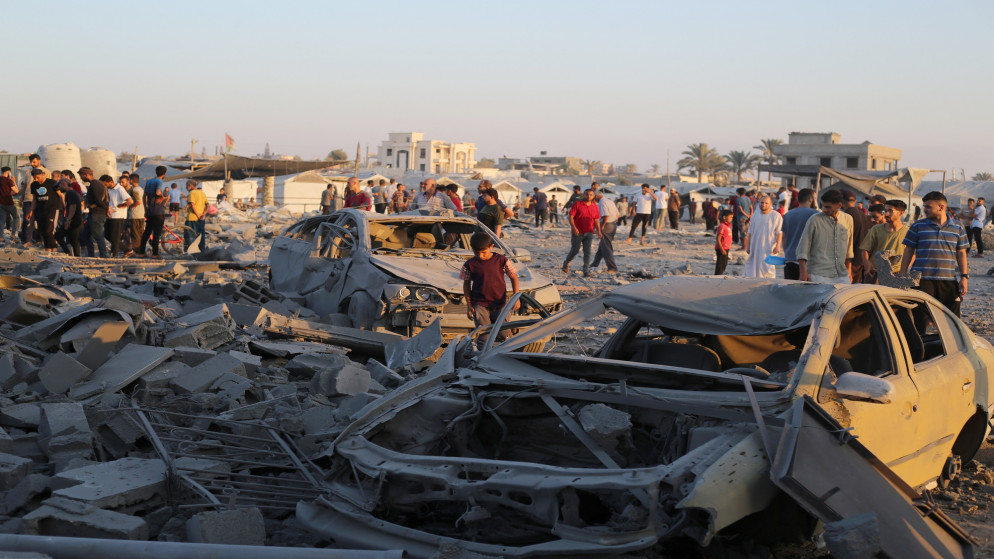 فلسطينيون يتفقدون الأضرار التي لحقت بممتلكاتهم في مخيم البريج وسط قطاع غزة، إثر قصف إسرائيلي، 27 حزيران 2025 (أ ف ب).