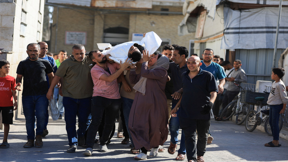 فلسطينيون يحملون جثمان شهيد بالقرب من مدرسة تؤوي نازحين، مستشفى الأهلي العربي في مدينة غزة، 28 حزيران 2025. (رويترز)