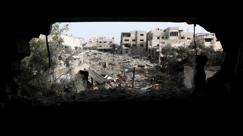 فلسطينيون يتفقدون موقع غارة إسرائيلية على منزل وسط قطاع غزة. 1 تموز 2025. (رويترز)
