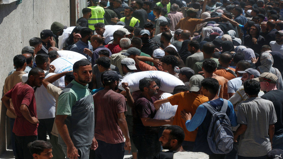 فلسطينيون يتجمعون لتلقي المساعدات بما في ذلك الإمدادات الغذائية في مركز توزيع في مدينة غزة. 26 حزيران 2025. (رويترز)