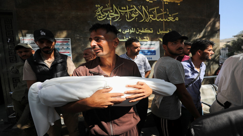 فلسطيني يحمل جثمان شهيد في مستشفى الشفاء في مدينة غزة. 27 تموز 2025. (رويترز)