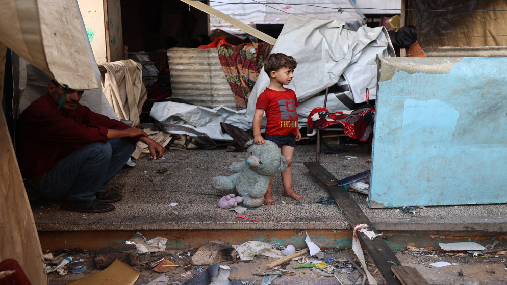 طفل فلسطيني يحمل دمية في مدرسة تؤوي نازحين في مخيم البريج وسط قطاع غزة، 8 تموز 2025. (أ ف ب)