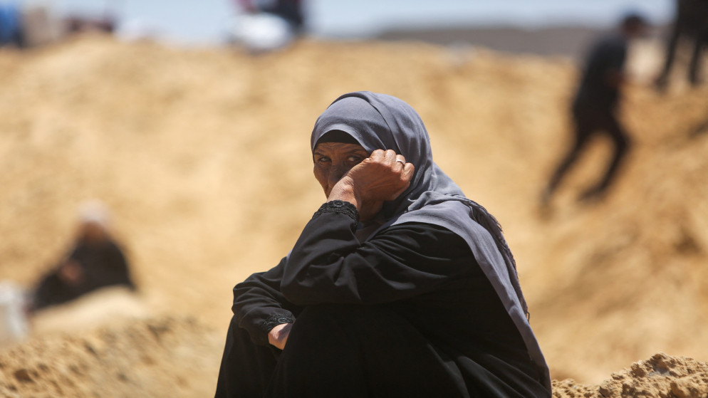 مسنة فلسطينية تجلس على أنقاض المأساة في قطاع غزة. (أ ف ب)