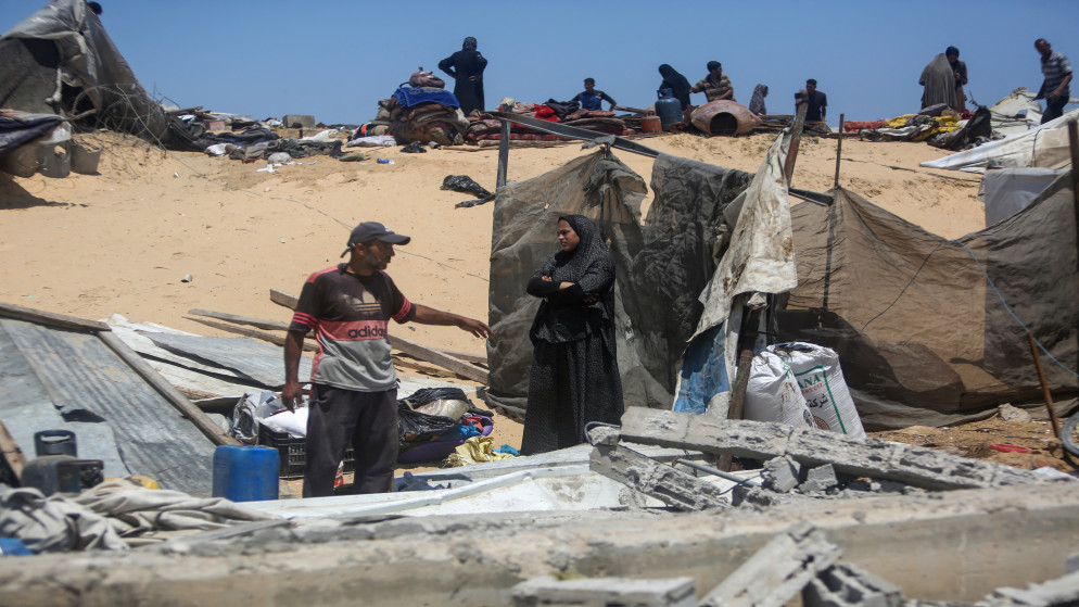 فلسطينيون يتفقدون الدمار في خان يونس جنوبي قطاع غزة. 11 تموز 2025. (أ ف ب)