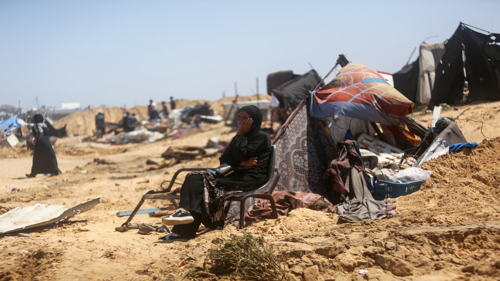 سيدة فلسطينية تجلس على أنقاض المأساة في غزة. (أ ف ب)