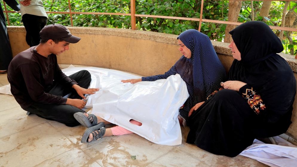 فلسطينية تحمل جثمان ابنتها الشهيدة أثناء جنازتها في مستشفى ناصر في خان يونس، جنوبي قطاع غزة، 14 تموز 2025. (رويترز)