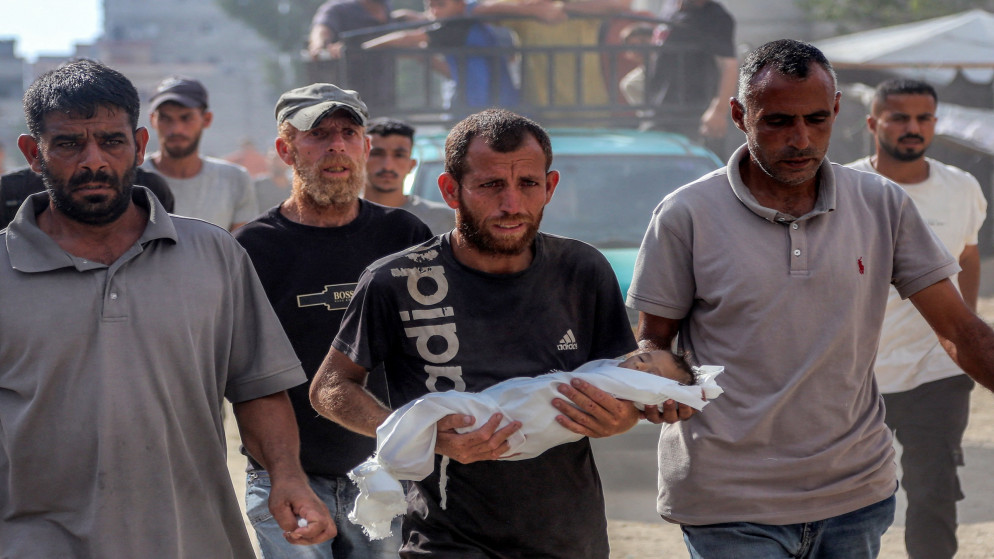 فلسطيني يحمل جثمان رضيع توفي بسبب سوء التغذية نتيجة الحرب الإسرائيلية على القطاع في مجمع ناصر الطبي في خان يونس بجنوب قطاع غزة .20 تموز/ يوليو 2025. (أ ف ب)