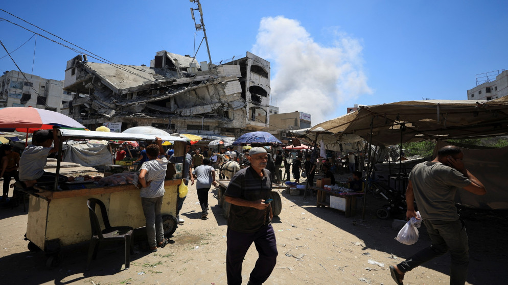 فلسطينيون يسيرون في أعقاب الغارات الإسرائيلية على المباني في سوق البلدة القديمة في غزة، في مدينة غزة، 9 تموز 2025. (رويترز)