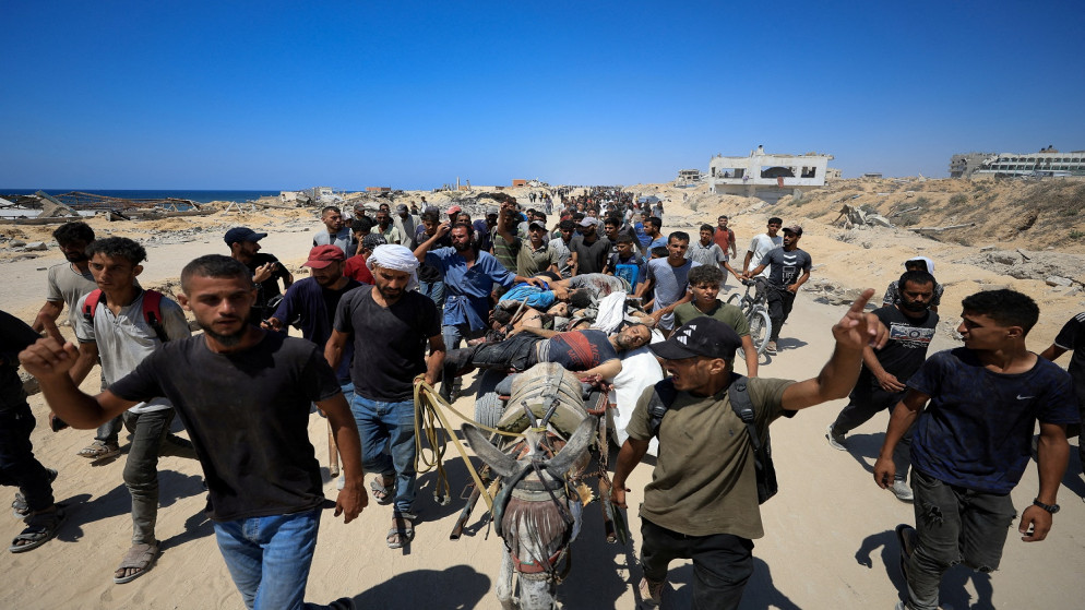 فلسطينيون ينقلون مصابين أثناء حصولهم على مساعدات في شمال قطاع غزة 20 تموز 2025. (رويترز)