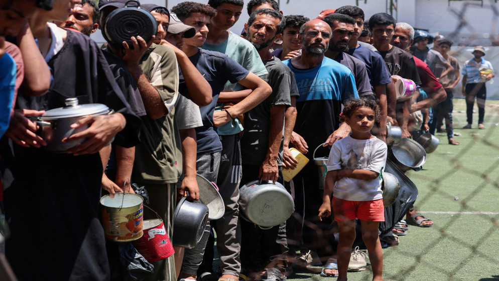 فلسطينيون يصطفون لتلقي الطعام من مطبخ خيري في النصيرات، وسط قطاع غزة، 20 تموز 2025. (رويترز)