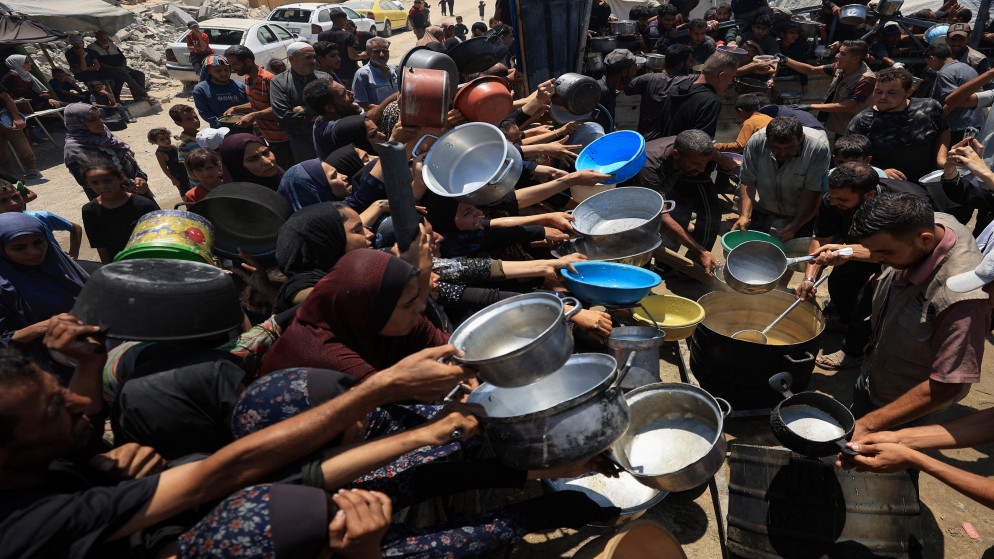 فلسطينيون يتجمعون لتلقي الطعام في مدينة غزة. 22 تموز 2025. (رويترز)