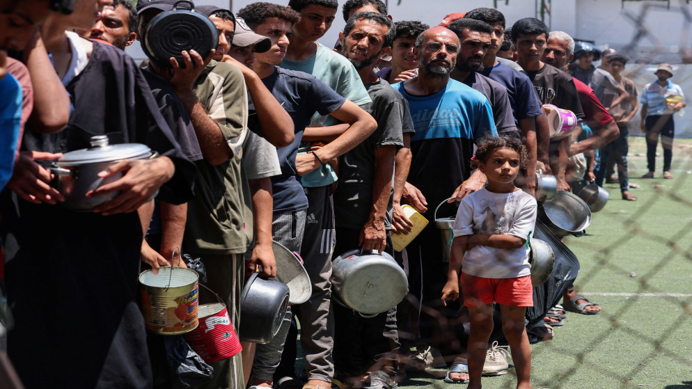 فلسطينيون يصطفون لتلقي الطعام من مطبخ خيري في النصيرات، وسط قطاع غزة، 20 تموز 2025. (رويترز)