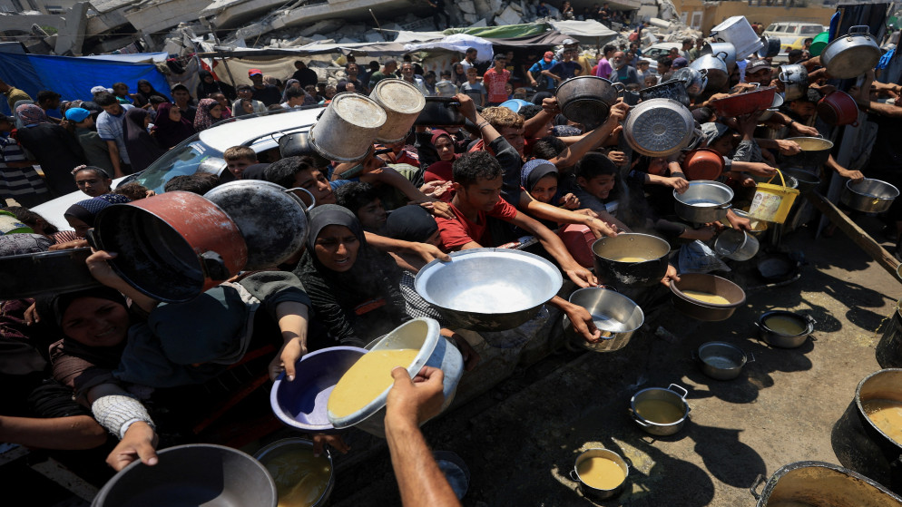 فلسطينيون يتجمعون لتلقي الطعام من مطبخ خيري وسط أزمة جوع في مدينة غزة. 25 تموز 2025. (رويترز)