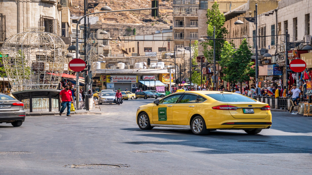 مشهد عام من وسط العاصمة ويظهر فيه مركبة نقل عام.