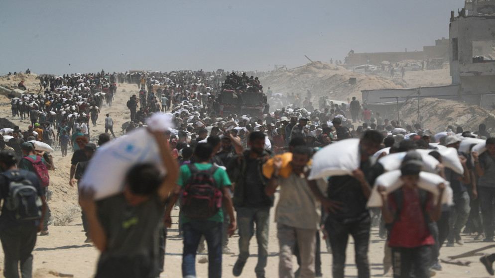 فلسطينيون يحملون إمدادات مساعدات دخلت إلى بيت لاهيا، شمال قطاع غزة، 27 تموز 2025. (رويترز)