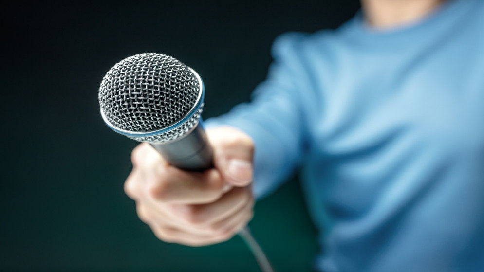 صورة توضيحية لشخص يحمل ميكروفونا لإجراء مقابلة. (iStockphoto)