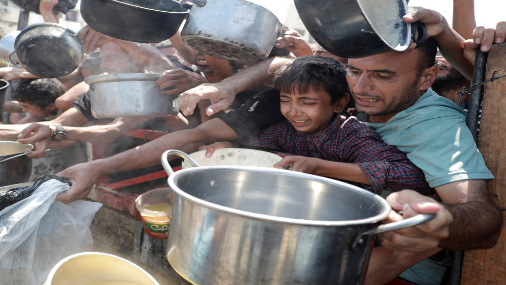 فلسطينيون يتجمعون لتلقي الطعام من مطبخ خيري في مدينة غزة. 28 تموز 2025. (رويترز)