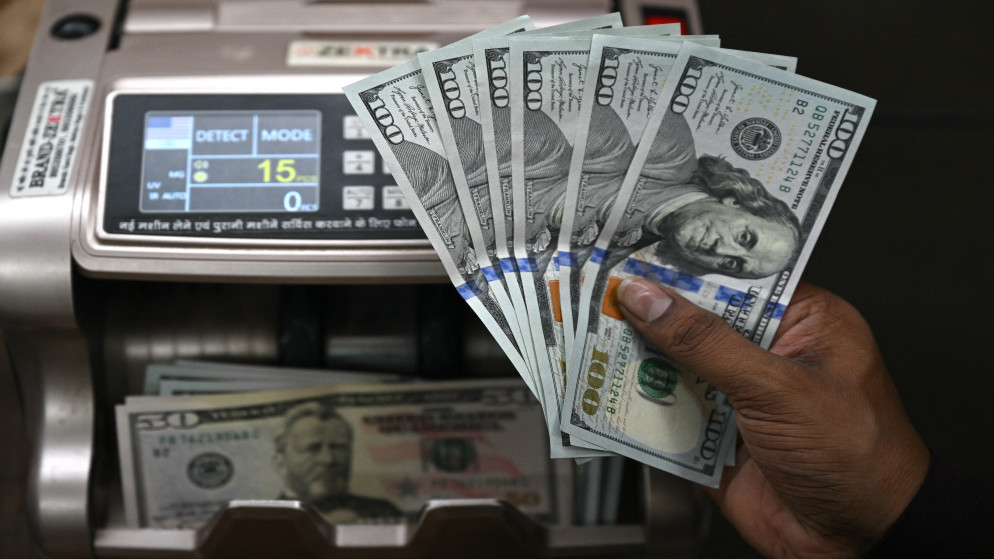عامل يحمل أوراقا نقدية من الدولار، 31 تموز 2025. (أ ف ب)