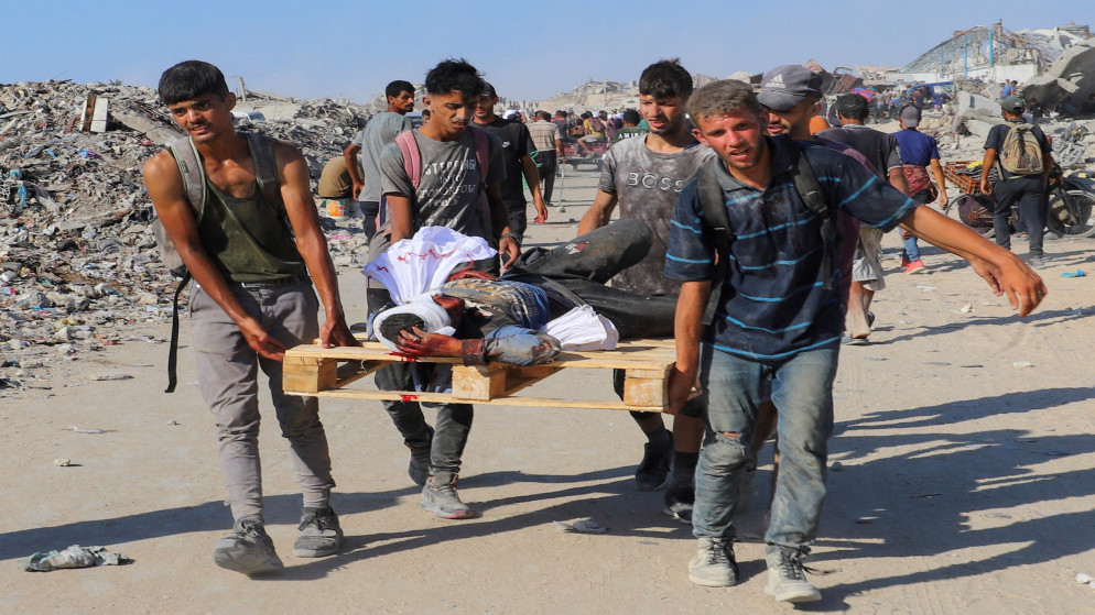فلسطينيون يسعفون شخصًا أصيب خلال انتظاره المساعدات في غزة. (رويترز)