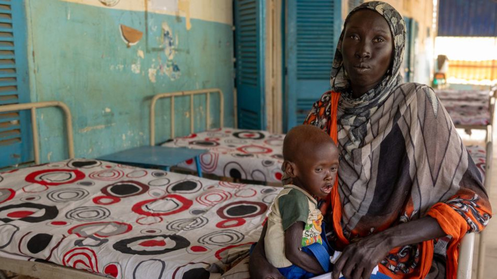 سيدة تحتضن طفلها الذي يعاني من سوء التغذية في مستشفى بولاية النيل الأزرق في السودان. (الأمم المتحدة)