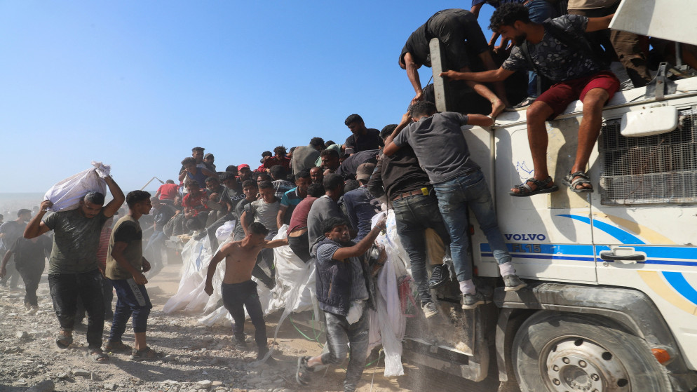 فلسطينيون يحاولون الوصول إلى المساعدات على متن شاحنة في بيت لاهيا شمال قطاع غزة. 3 آب 2025. (رويترز)
