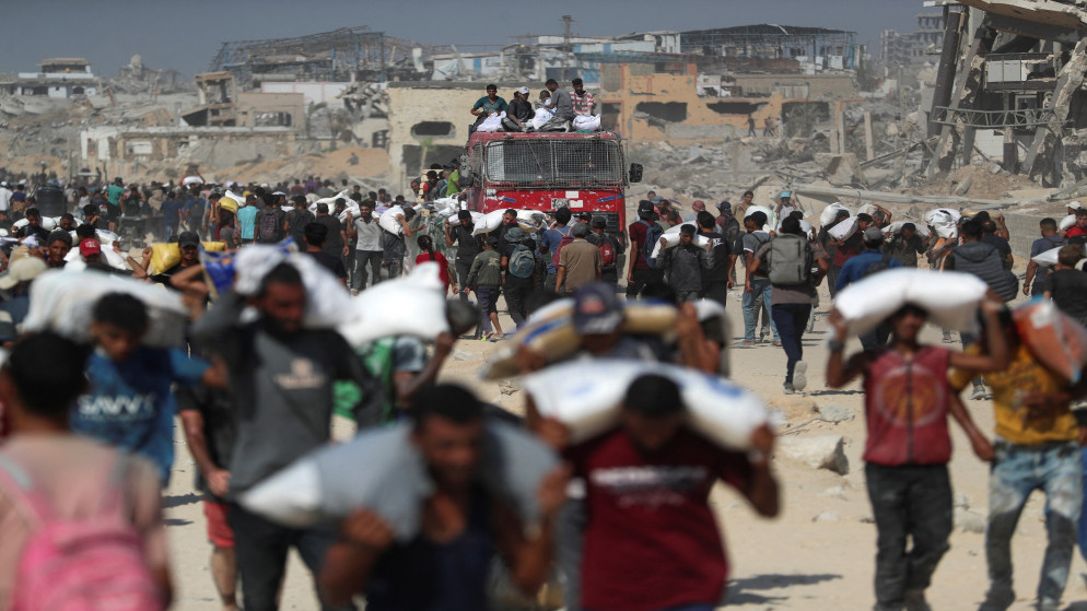 فلسطينيون يحملون إمدادات مساعدات دخلت غزة في بيت لاهيا شمال قطاع غزة. 2 آب 2025. (رويترز)