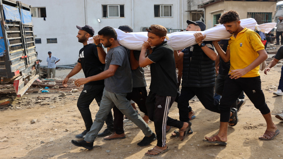يحمل فلسطينيون جثمان شهيد ارتقى أثناء طلب المساعدة بالقرب من زيكيم، غرب بيت لاهيا، في شمال قطاع غزة. 10 أغسطس 2025. (أ ف ب)