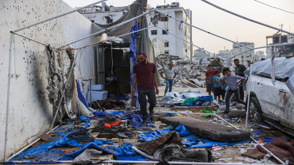 فلسطينيون يتفقدون خيمة مدمرة في مستشفى الشفاء بمدينة غزة عقب غارة جوية إسرائيلية، 11 آب 2025 (أ ف ب)