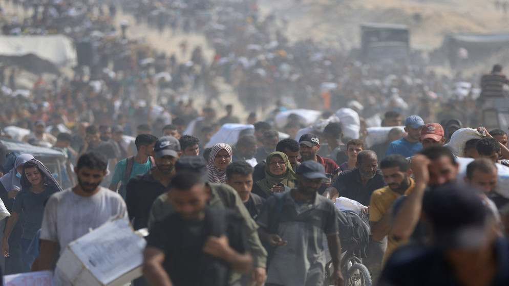 فلسطينيون يحملون إمدادات إغاثة جمعوها من الشاحنات التي دخلت غزة في بيت لاهيا شماليّ قطاع غزة. 10 آب 2025. (رويترز)