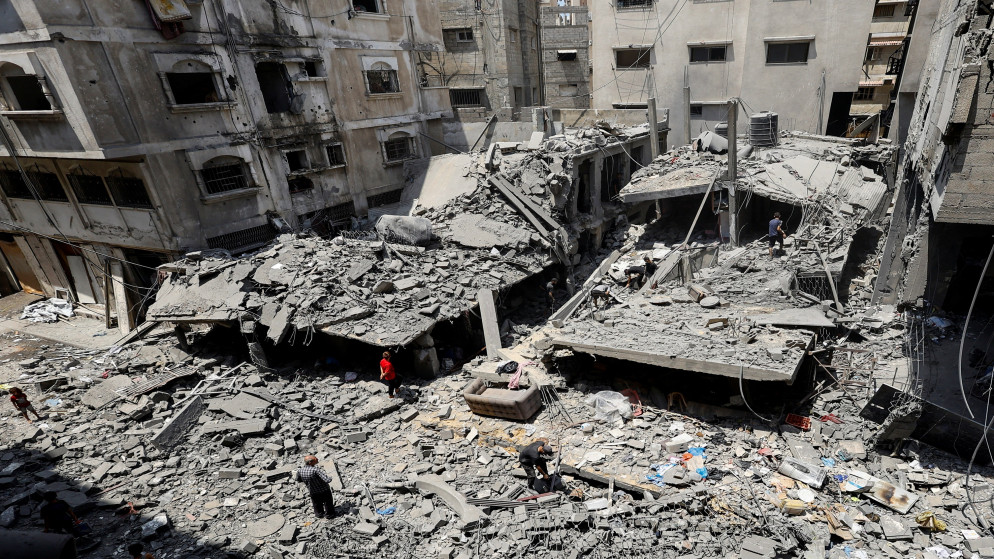 فلسطينيون يتفقدون موقع غارة إسرائيلية في مدينة غزة. 8 آب 2025. (رويترز)