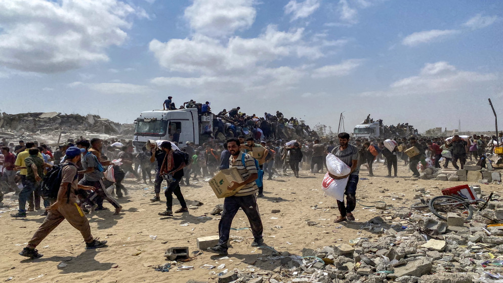 فلسطينيون يتجمعون لتلقي المساعدات في غزة، 22 حزيران 2025. (رويترز)