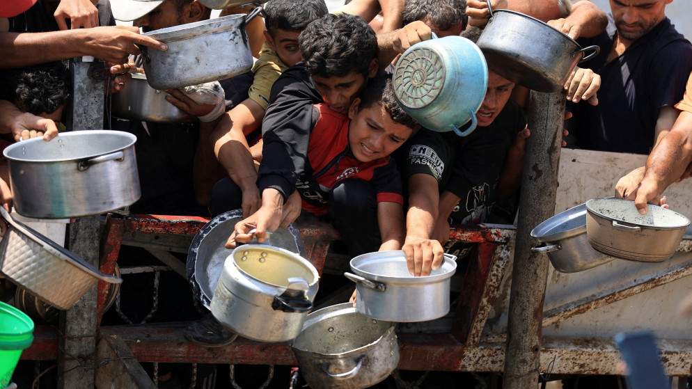 فلسطينيون ينتظرون الحصول على الطعام من مطبخ خيري في مدينة غزة، 15 آب 2025. (رويترز)