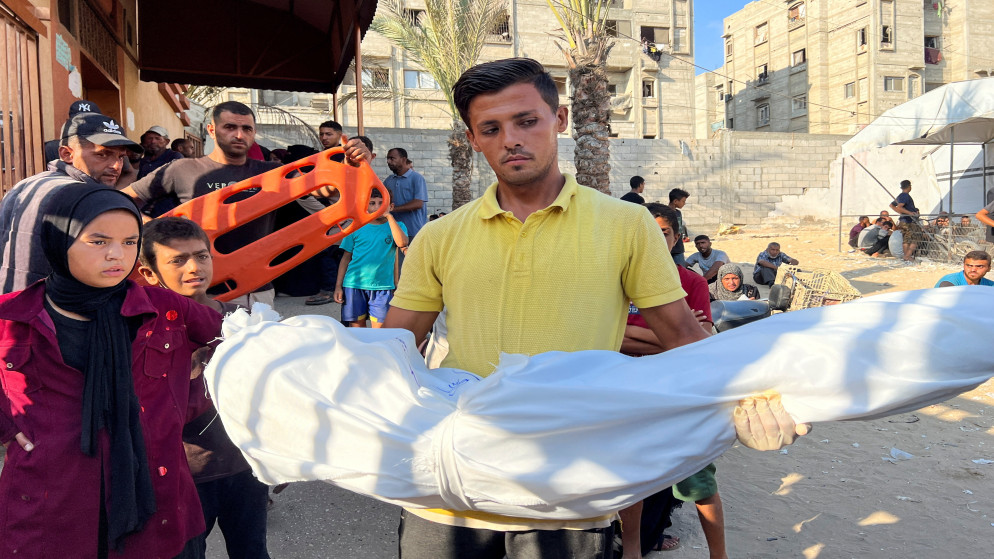 فلسطيني يحمل جثمان شهيد في خان يونس جنوب قطاع غزة 23 آب 2025. (رويترز)