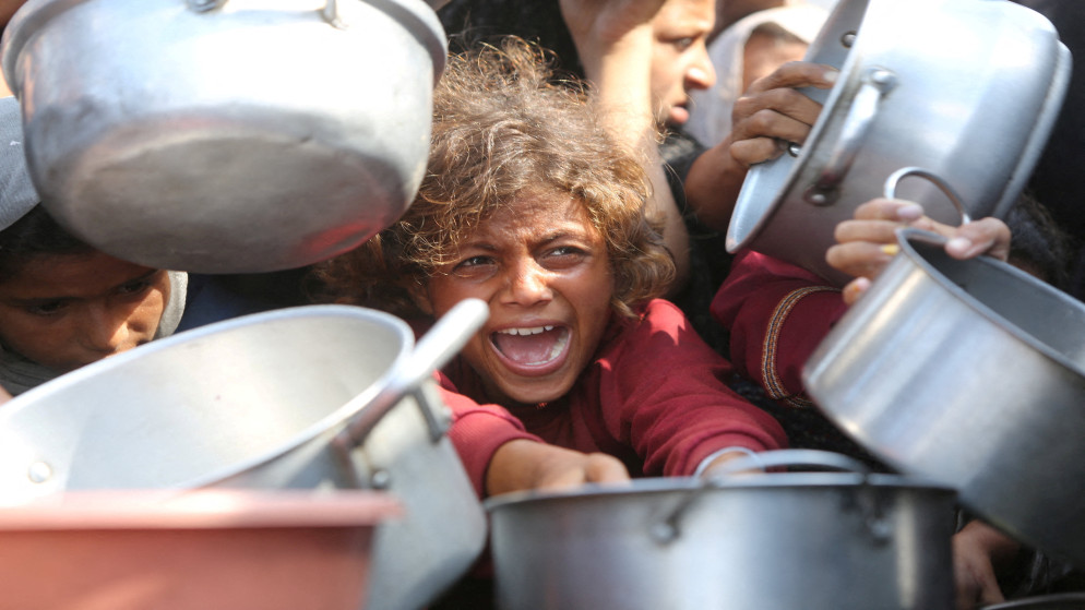 طفل فلسطيني ينتظر الحصول على الطعام من مطبخ خيري في خان يونس، جنوب قطاع غزة، 21 آب 2025. (رويترز)