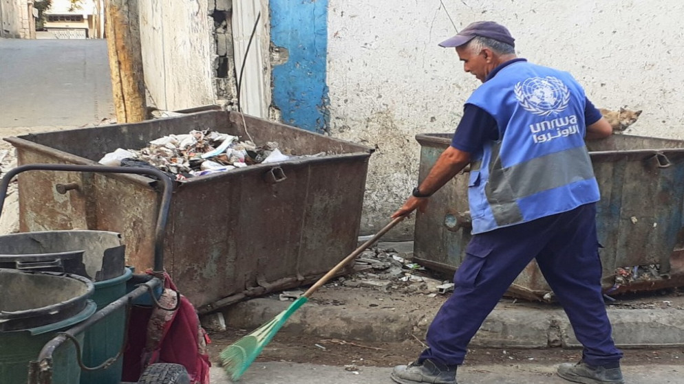 جانب من عمل أحد موظفي وكالة الأونروا خلال جمع النفايات الصلبة في قطاع غزة. (الأونروا)