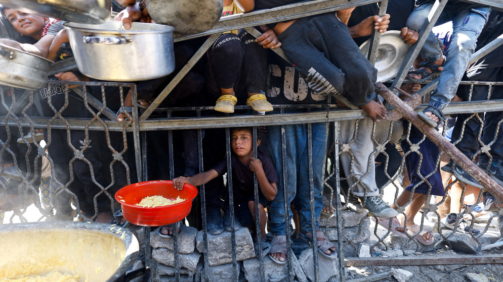 فلسطينيون ينتظرون الحصول على الطعام من مطبخ خيري في مدينة غزة، 28 آب 2025. (رويترز)