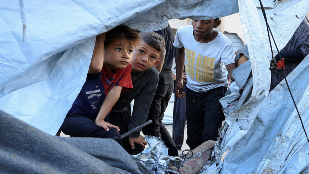 أطفال فلسطينيون ينظرون إلى موقع غارة إسرائيلية على خيمة في مدينة غزة. 5 أيلول 2025. (رويترز)