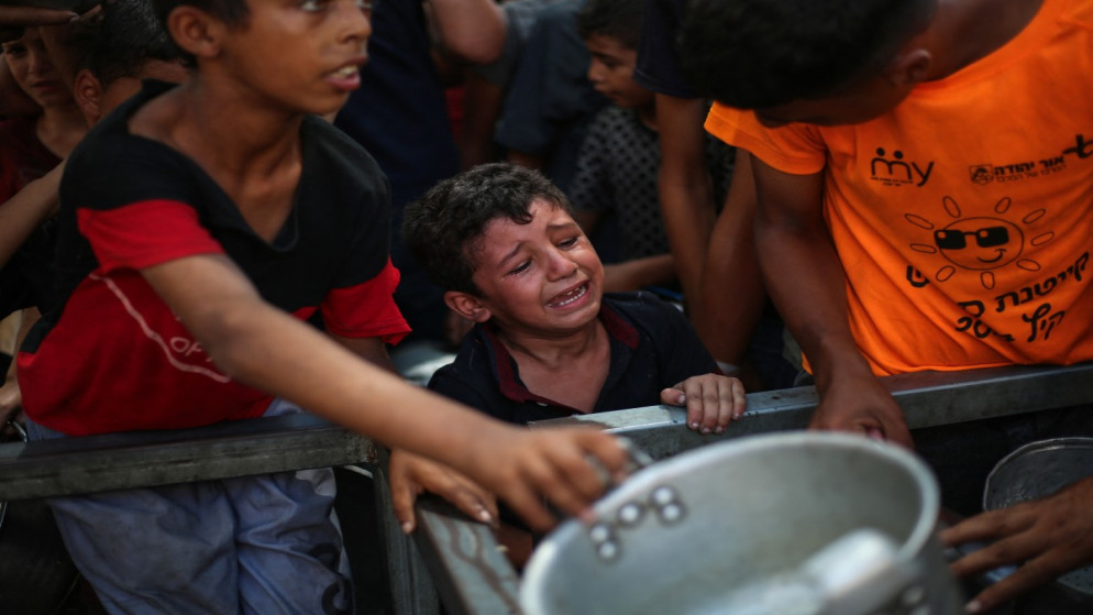 طفل فلسطيني يبكي في أثناء انتظاره وجبة من مطبخ في مخيم النصيرات. قطاع غزة. 4 أيلول 2025. (أ ف ب)