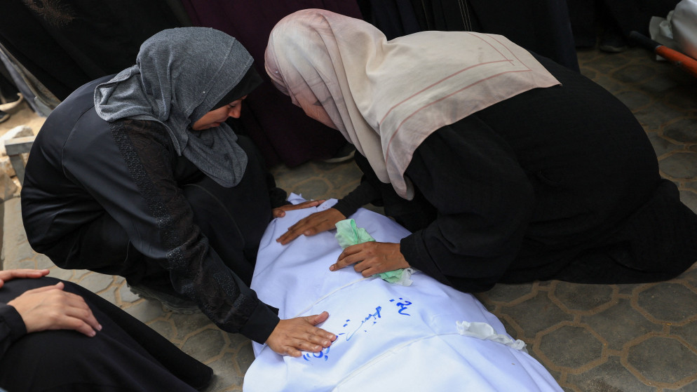 فلسطينيتان بالقرب من جثمان شهيد في مستشفى الشفاء بمدينة غزة، 4 أيلول 2025. (رويترز)