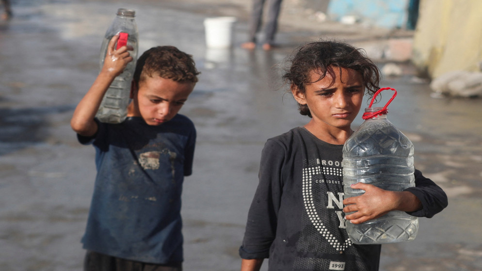 أطفال فلسطينيون يمشون بالمياه وسط نقص المياه في مدينة غزة. 3 أيلول 2025. (رويترز)