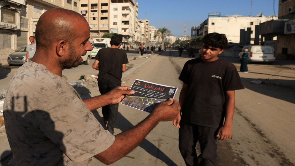 فلسطيني يحمل منشورا ألقته قوات الاحتلال الإسرائيلي، يأمر سكان مدينة غزة بالإخلاء، 9 أيلول 2025. (رويترز)