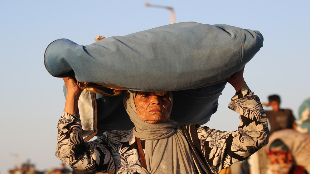 نازحة فلسطينية تتجه جنوبًا مع أمتعتها على طريق في مخيم النصيرات للاجئين وسط قطاع غزة، 20 سبتمبر/أيلول 2025. (أ ف ب)