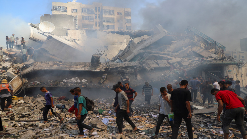 فلسطينيون بالقرب من موقع غارات إسرائيلية على مبانى سكني في مدينة غزة، 22 أيلول 2025. (رويترز)
