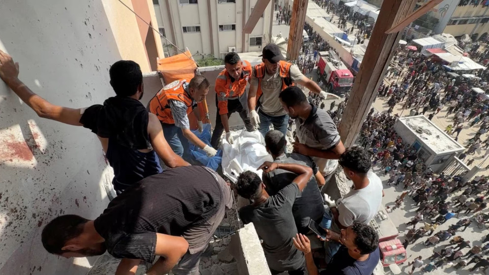رجال إنقاذ يعملون على انتشال جثة صحفيين استهدفهم جيش الاحتلال الإسرائيلي في مستشفى ناصر في غزة، 25 آب 2025. (رويترز)