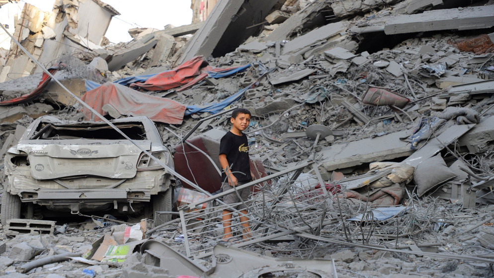 طفل فلسطيني يقف وسط الأنقاض أثناء تفقده موقع الغارات الإسرائيلية على منازل في مخيم الشاطئ للاجئين، في مدينة غزة، 26 سبتمبر/أيلول 2025. (رويترز)