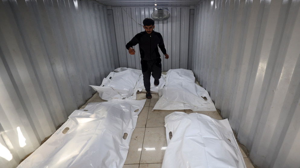 فلسطيني يمشي بين جثث شهداء داخل هيكل حديدي، في وسط قطاع غزة، عقب غارة إسرائيلية في 27 أيلول 2025. (أ ف ب)