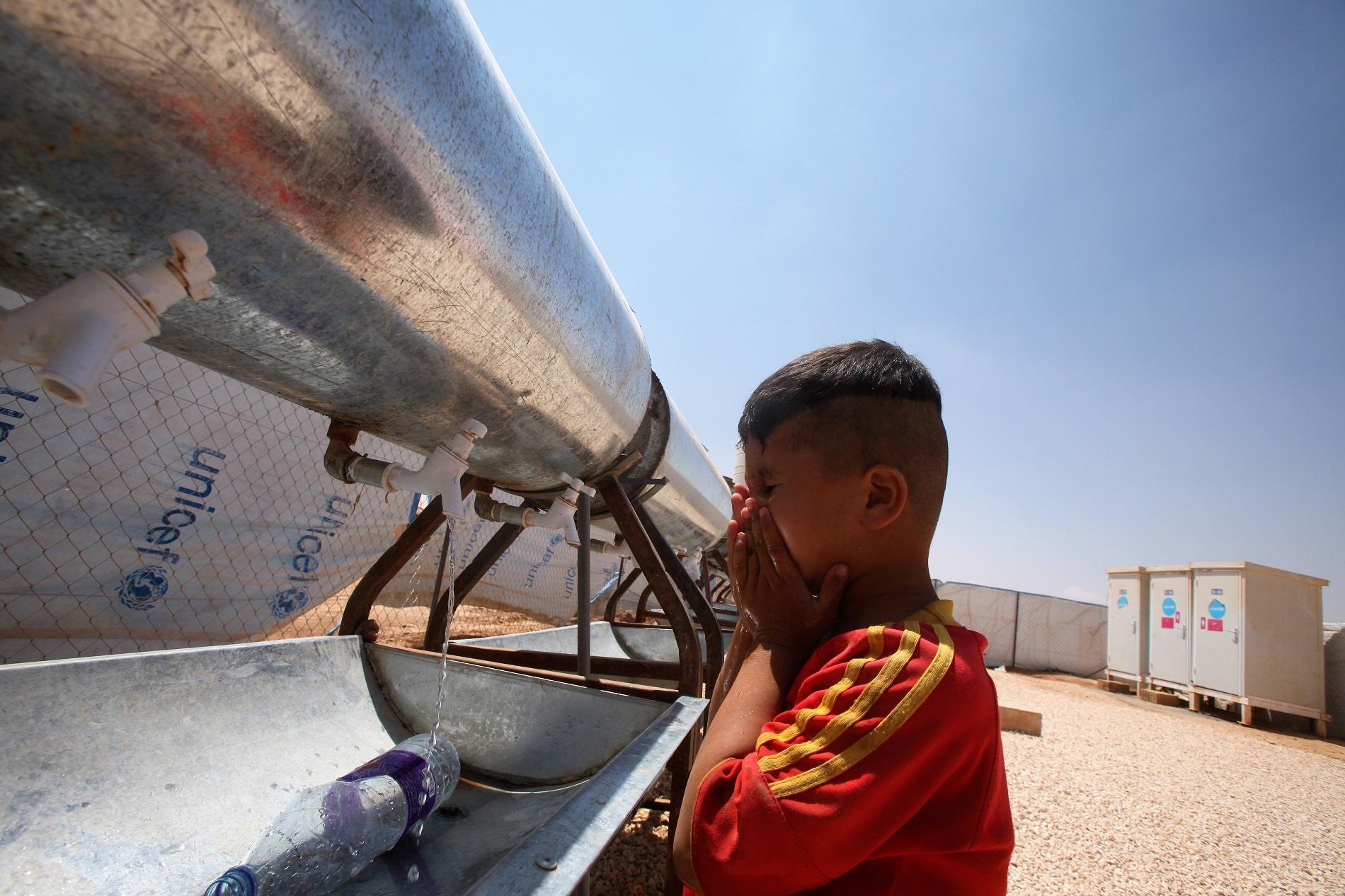 طفل يغسل وجهه بالماء داخل مخيم الزعتري في محافظة المفرق شمالي الأردن. صلاح ملكاوي / المملكة