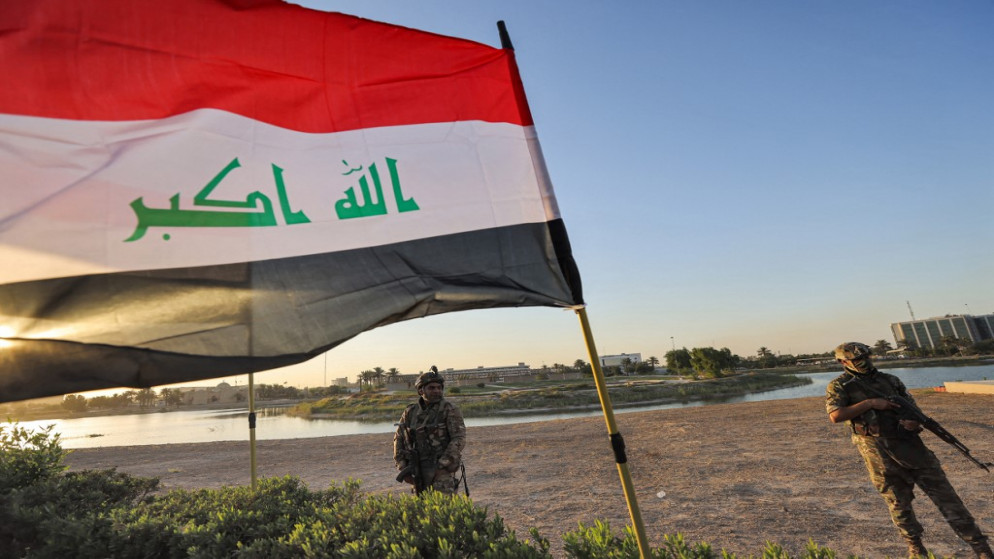 عناصر من قوات الحشد الشعبي العراقية شبه العسكرية يقفون في حراسة خلال تجمع انتخابي في العاصمة بغداد ،7 أكتوبر/ تشرين الأول 2021. (أ ف ب)